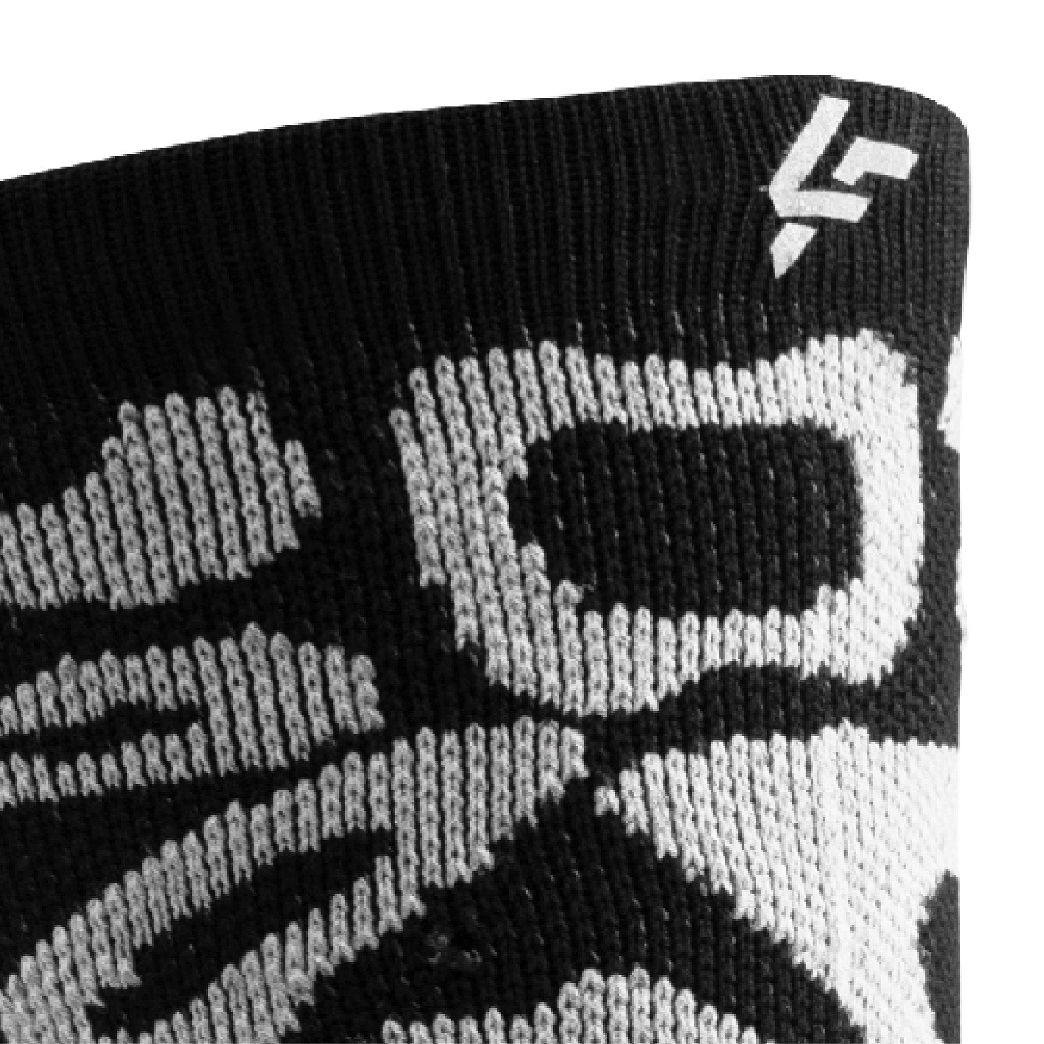 Close up view of reflective print symbol on Lightfeet Performance Scribbles Black White Crew Socks