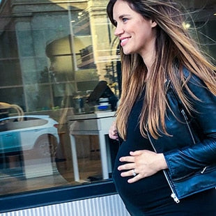 Pregnant woman walking along city street