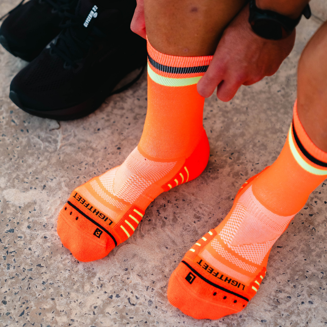 Image of person wearing Lightfeet Performance 2 Stripes Orange Black Yellow Crew Socks 