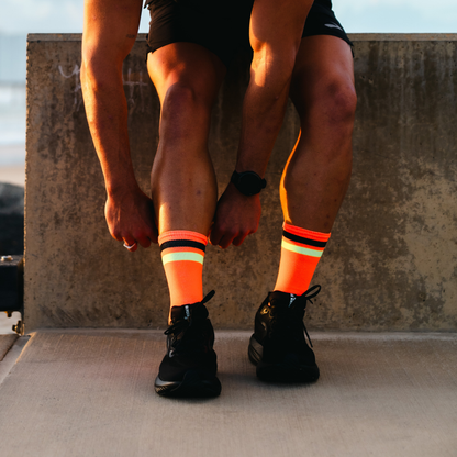 Image of person wearing Lightfeet Performance 2 Stripes Orange Black Yellow Crew Socks 