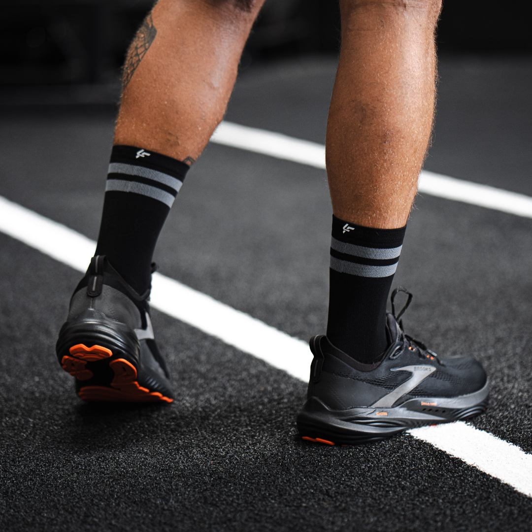 Image of person wearing Lightfeet Performance 2 Stripes Black Half Crew Socks 
