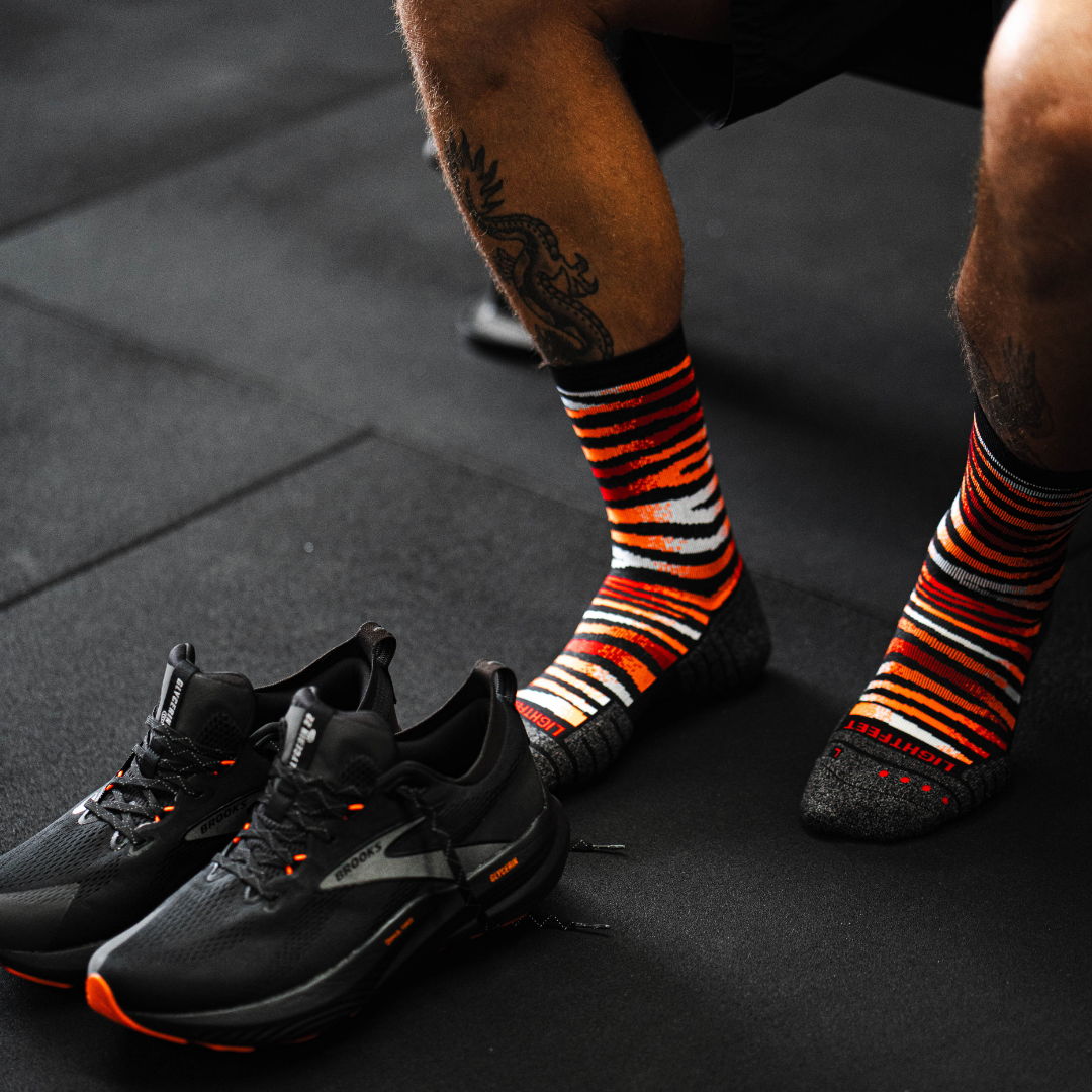 Image of person wearing Lightfeet Performance Predator Black Red Orange Half Crew Socks 