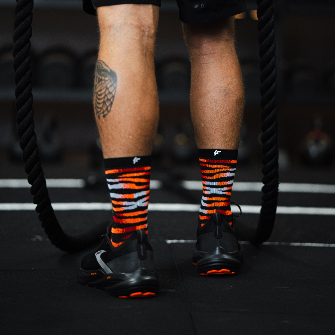 Image of person wearing Lightfeet Performance Predator Black Red Orange Half Crew Socks 