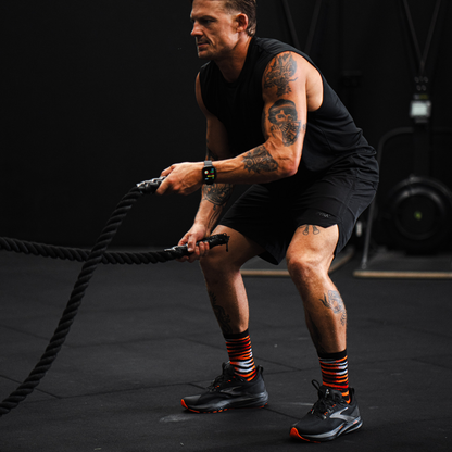 Image of person wearing Lightfeet Performance Predator Black Red Orange Half Crew Socks 
