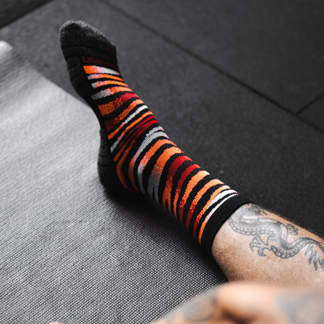 Image of person wearing Lightfeet Performance Predator Black Red Orange Half Crew Socks 
