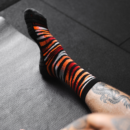 Image of person wearing Lightfeet Performance Predator Black Red Orange Half Crew Socks 