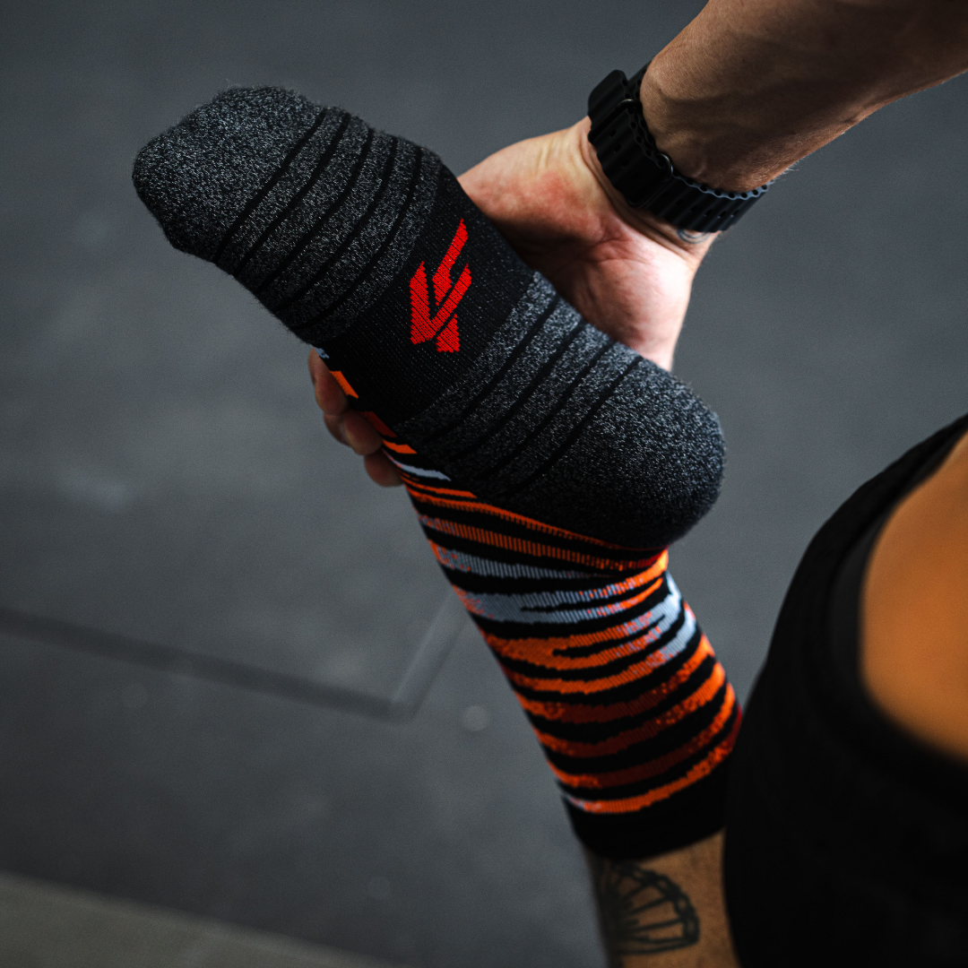 Image of person wearing Lightfeet Performance Predator Black Red Orange Half Crew Socks 
