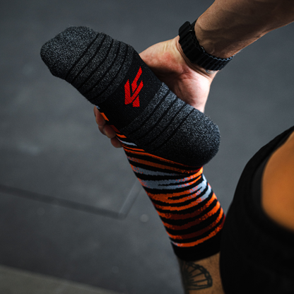 Image of person wearing Lightfeet Performance Predator Black Red Orange Half Crew Socks 