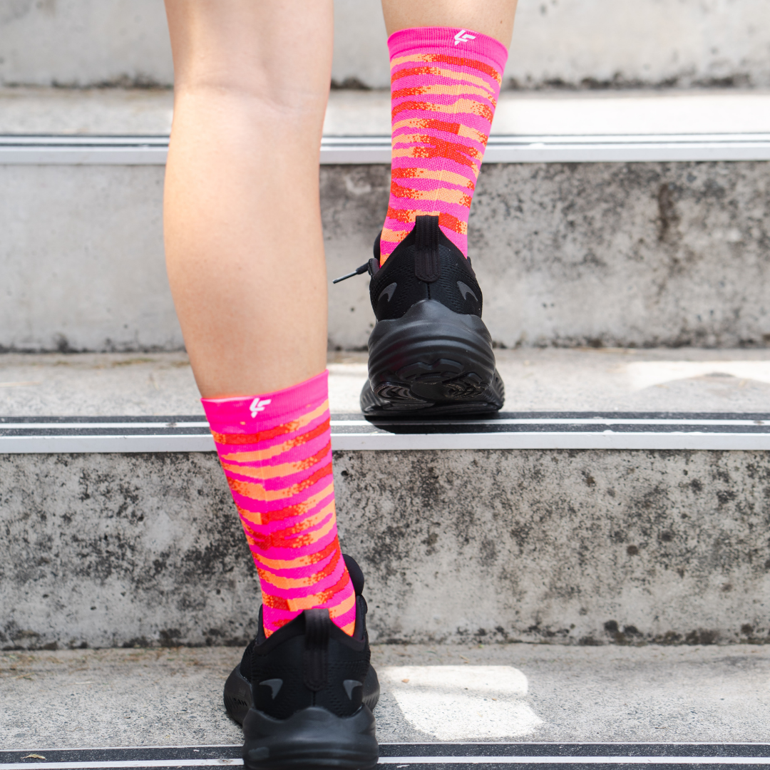 Image of person wearing Lightfeet Performance Predator Pink Red Orange Half Crew Socks 