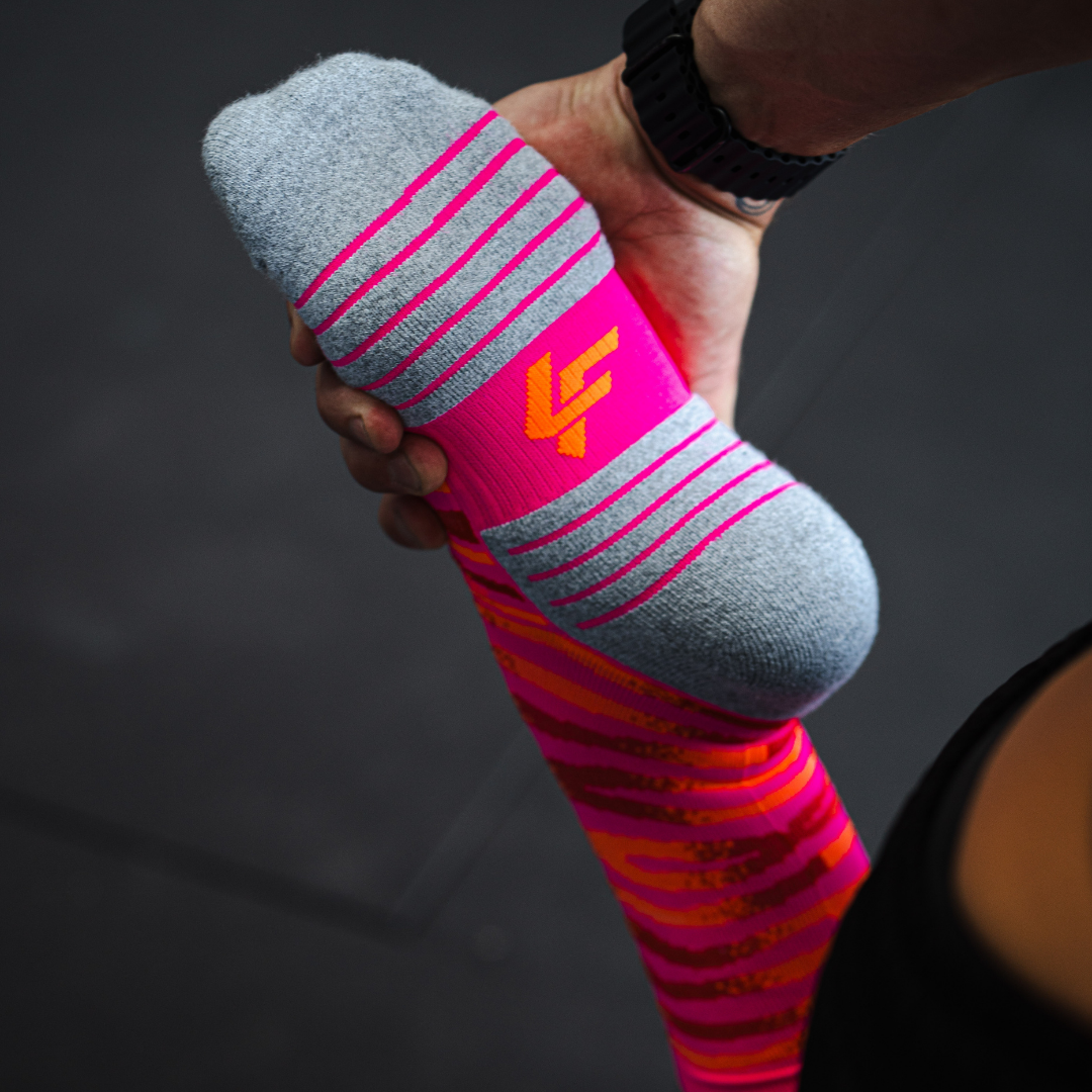Image of person wearing Lightfeet Performance Predator Pink Red Orange Half Crew Socks 