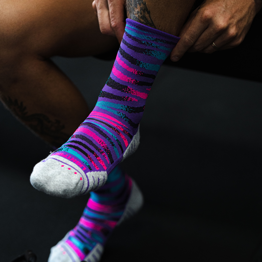 Image of person wearing Lightfeet Performance Predator Purple Aqua Pink Half Crew Socks 