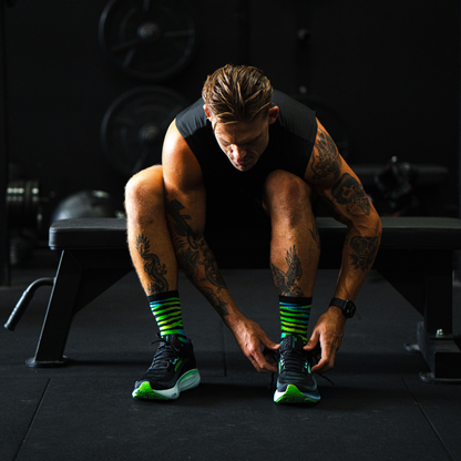 Image of person wearing Lightfeet Performance Predator Black Yellow Aqua Half Crew Sock 